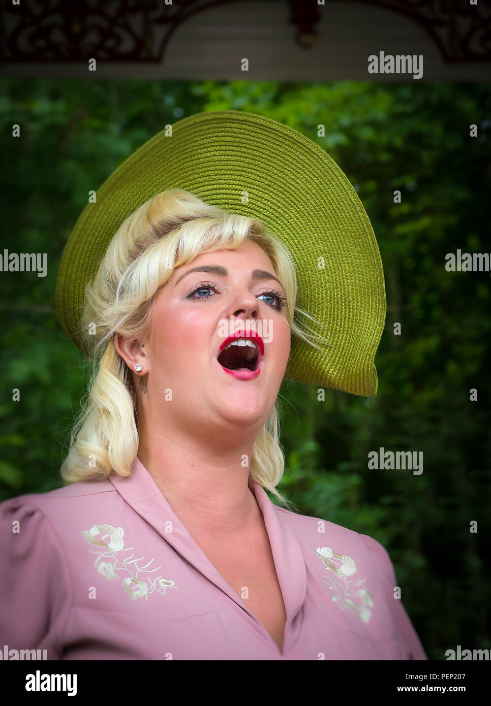 Weibliche, Vintage-Sängerin, die mit offener und kraftvoller Stimme singt, auf dem Bandstand, die das Publikum in der Crich Tramway, Veranstaltung 1940s, unterhielt. Stockfoto