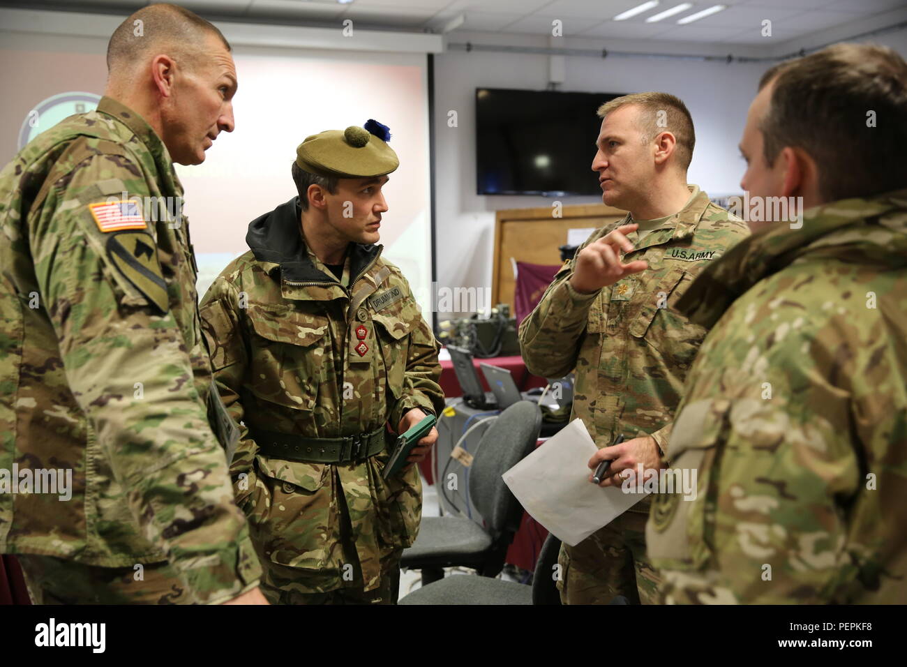 Us-Soldaten des 4. Bataillon, 319 Airborne Field Artillery Regiment, 173Rd Airborne Brigade und ein Britischer Soldat der Konzernzentrale, 4 Schotten, die Königliche Regiment von Schottland, Mitte, mögliche feindliche Stellungen diskutieren nach Durchführung einer Mission Bestellungen kurze bei der US Army Joint Multinational Readiness Center in Hohenfels, Deutschland, Jan. 21, 2016 während der Übung Allied Geist IV. Übung Allied Geist IV ist ein US-Army Europe, 7. Armee gemeinsame Multinationale Ausbildung Befehl durchgeführte multinationale Übung entwickelt, die Kräfte in Europa für den Betrieb vorbereiten Stockfoto