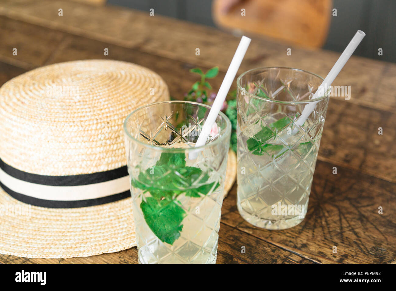 Straw hat und einen kleinen Blumenstrauß auf dem Tisch Stockfoto