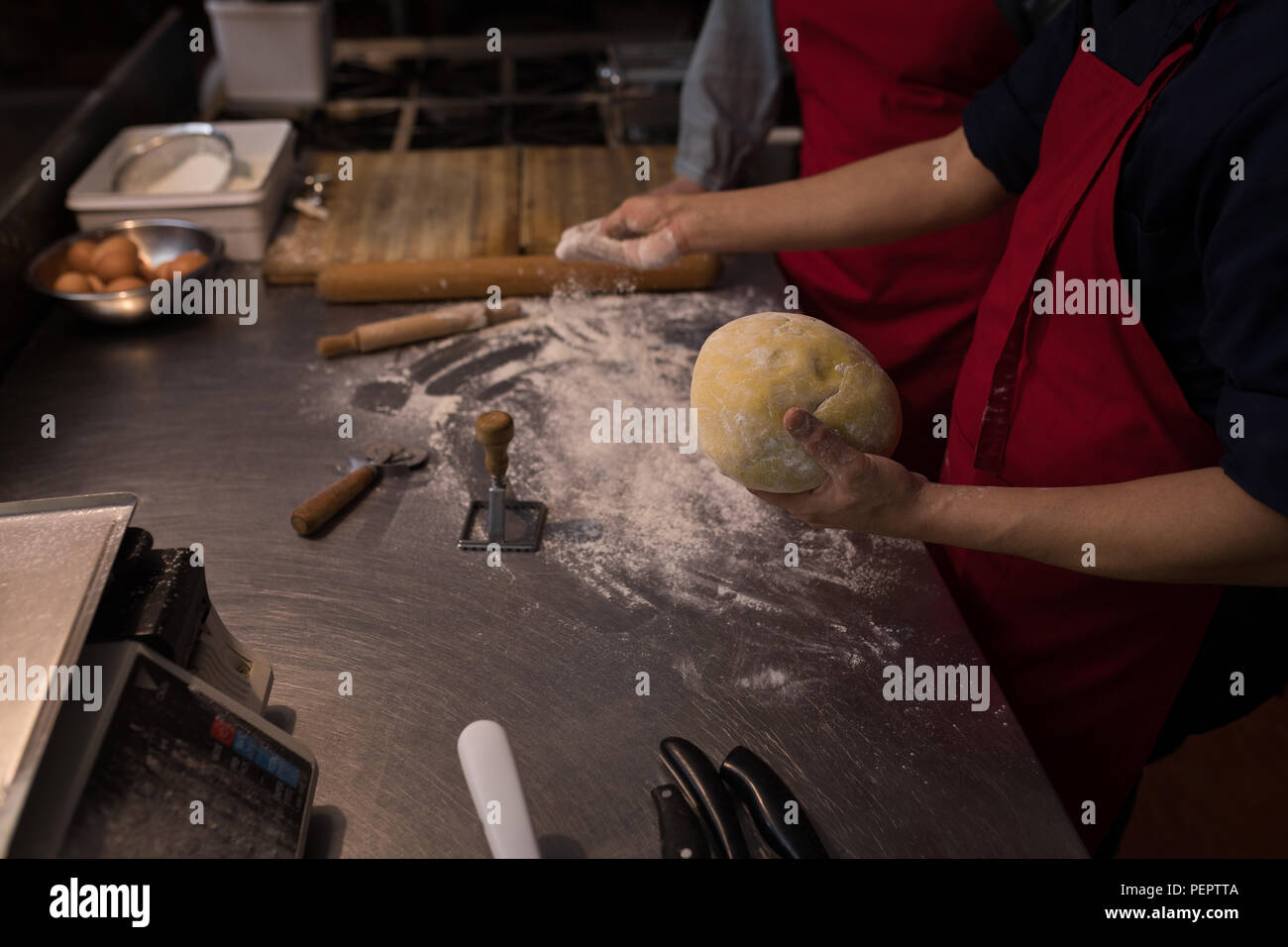 Baker, weißes Mehl auf den Teig Stockfoto
