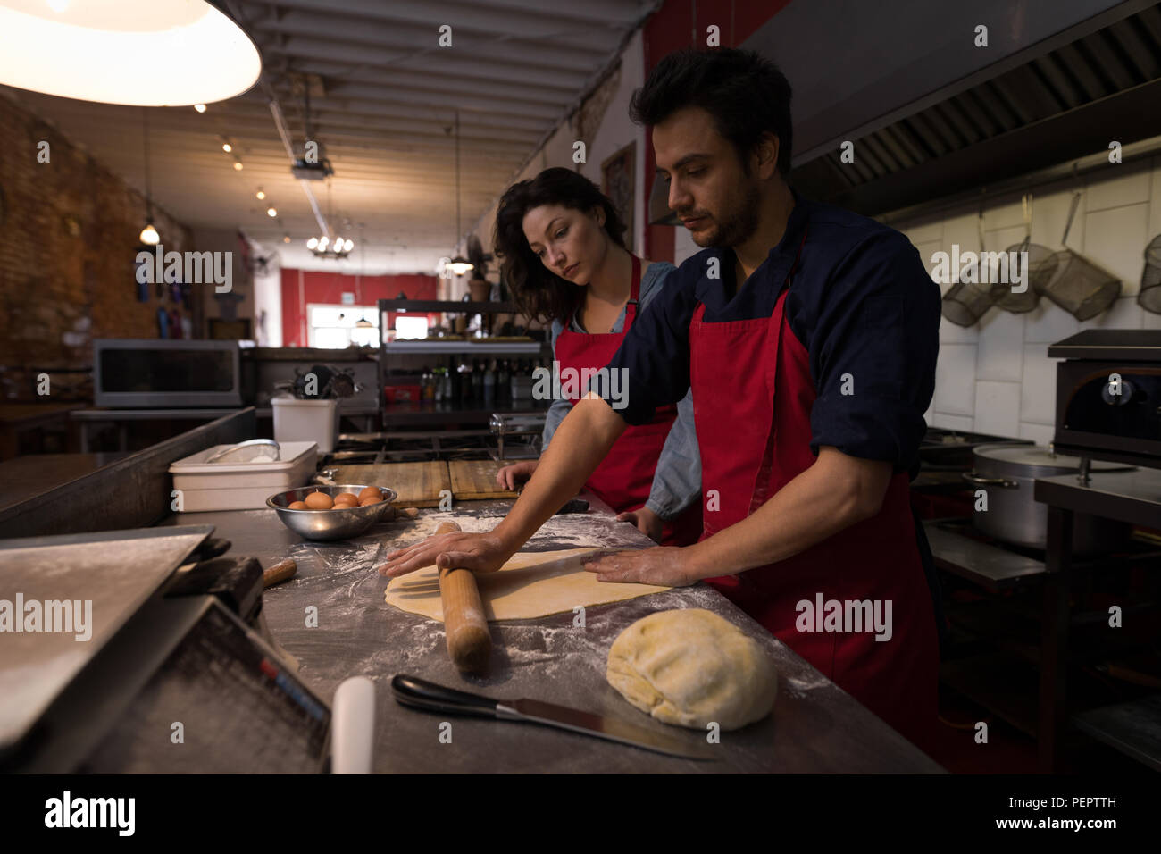 Männliche baker rollt Teig Mehl und Pasta Stockfoto