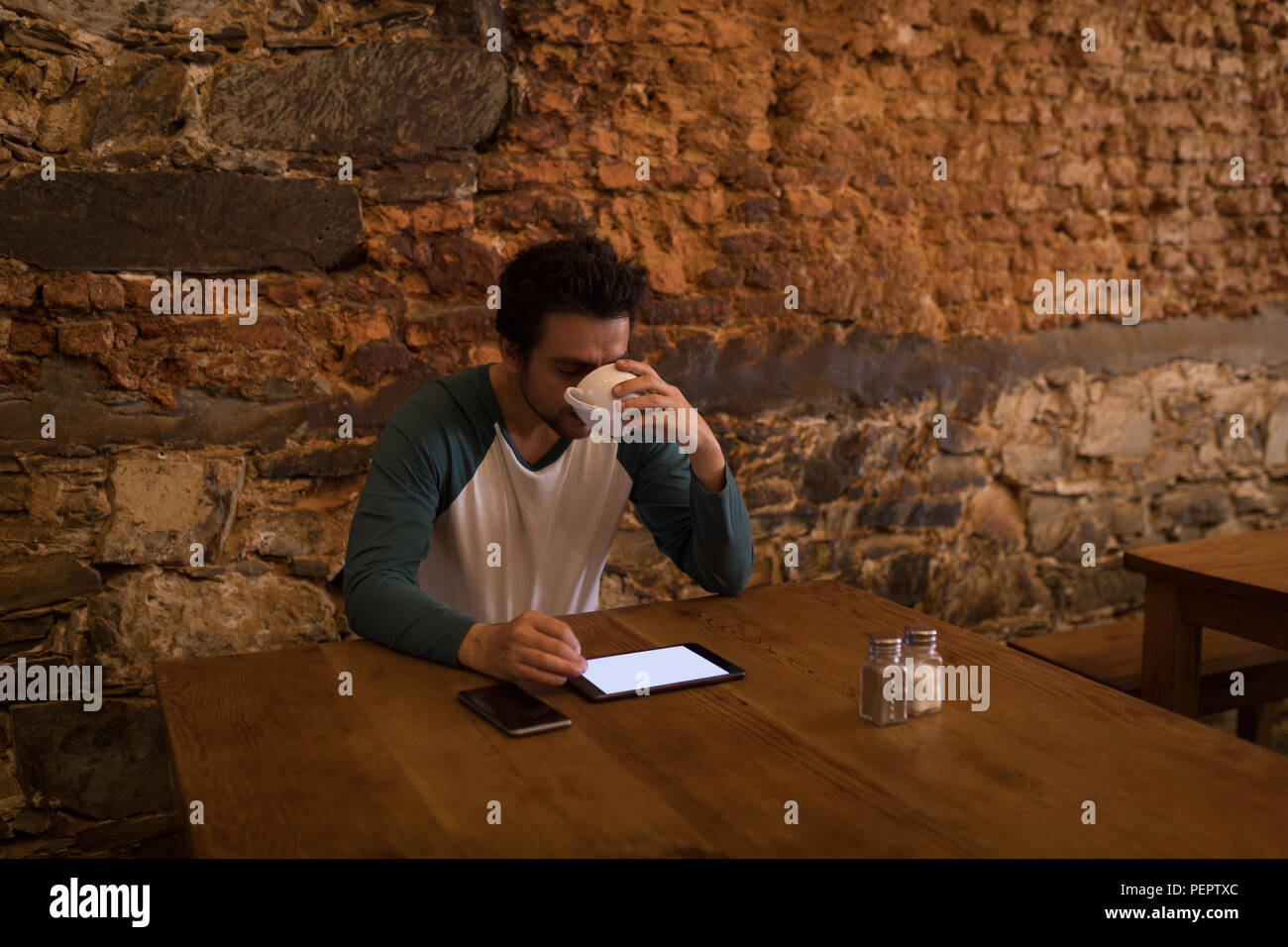 Unternehmer in Kaffee, während Sie ein digitales Register Stockfoto