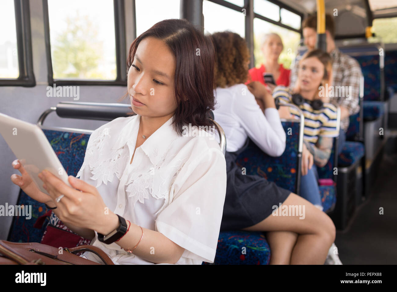 Weibliche Pendler mit digitalen Tablet bei Reisen im modernen Bus Stockfoto