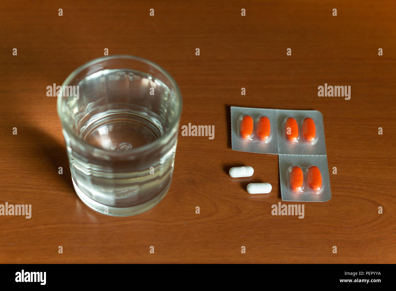 Konzeptionelle Glas Wasser und Pillen auf Holztisch. Stockfoto
