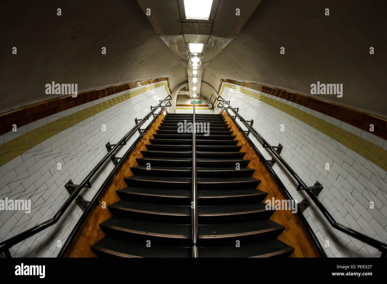 Ein Bild aus dem Tunnel der U-Bahn in London. Die Treppen und die klaustrophobische Umgebung. Stockfoto