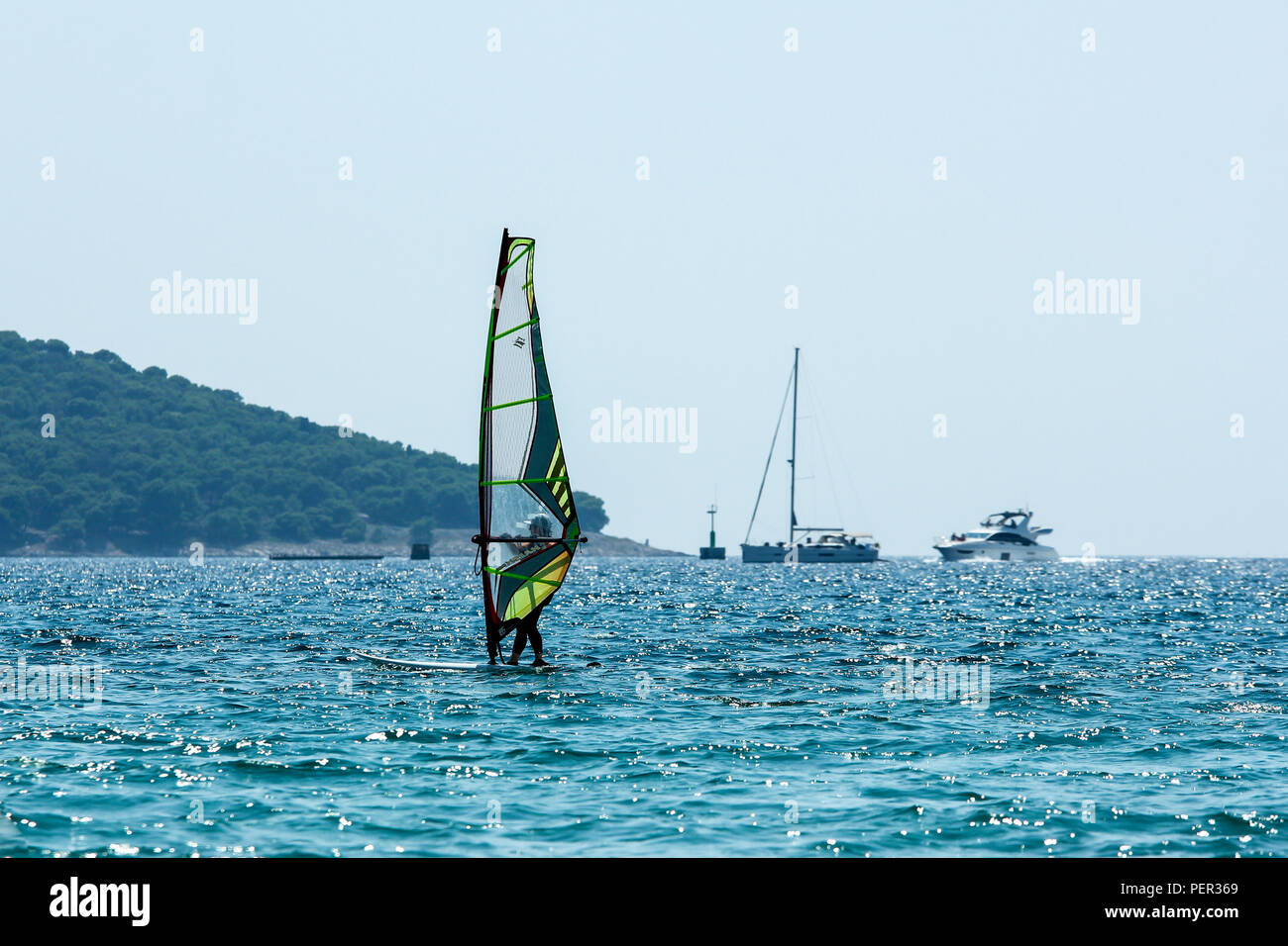 Ein Bild von einem einzigen Windsurfen auf dem Meer während der heißen Sommertag. Dargestellt in Kroatien. Stockfoto