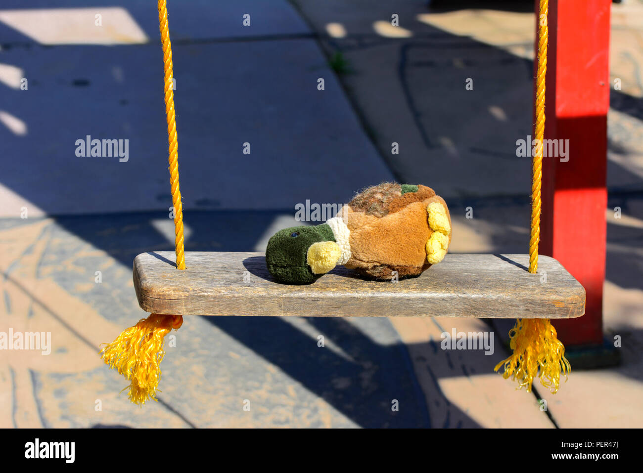 Weiche Kinder Spielzeug (Plüsch Ente) liegt auf einem Prüfstand für das Reiten mit gelben Seile gebunden. Das Konzept der Kinder- und Sommerferien. Stockfoto