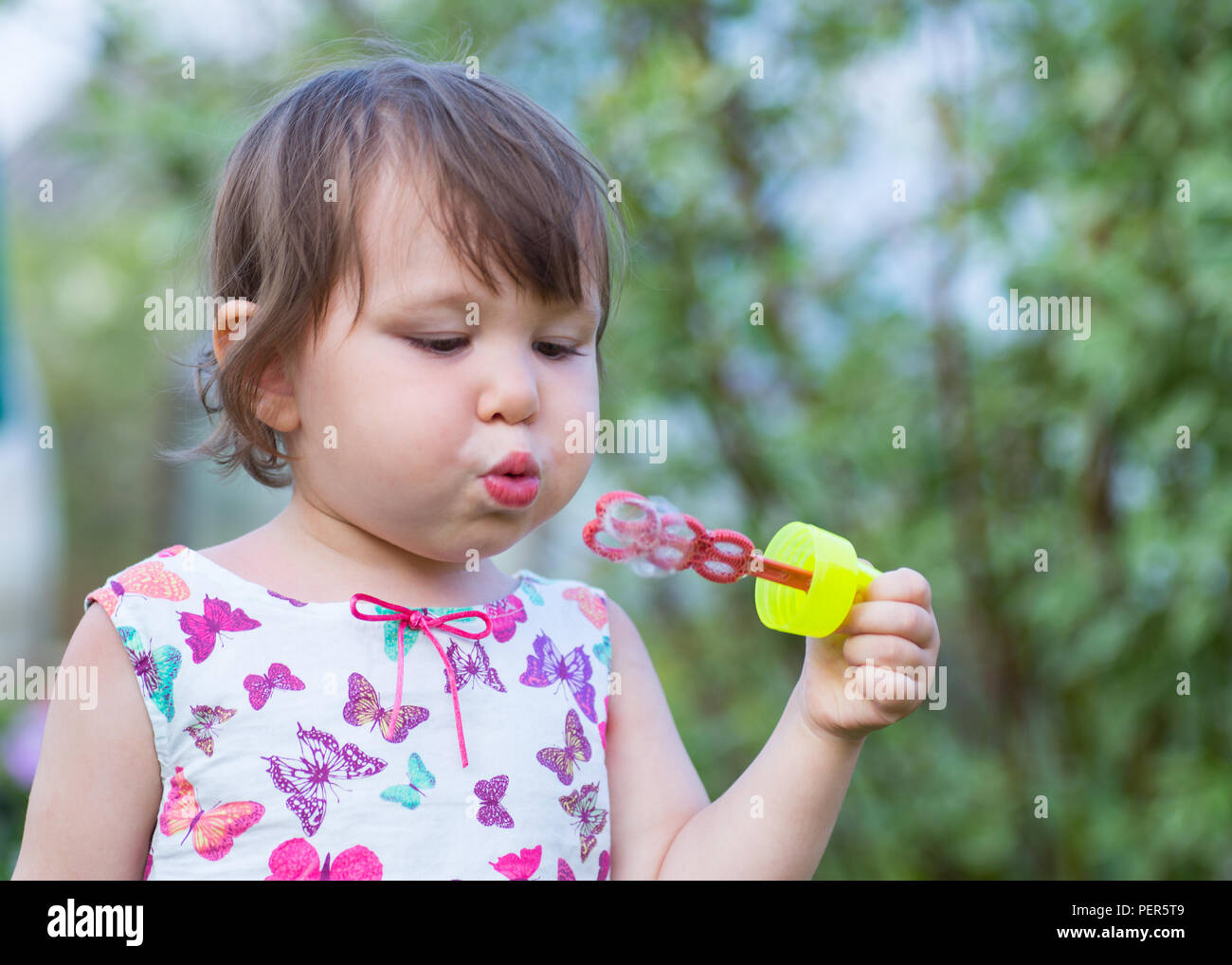Niedliche kleine Mädchen bläst ein Seifenblasen Stockfoto
