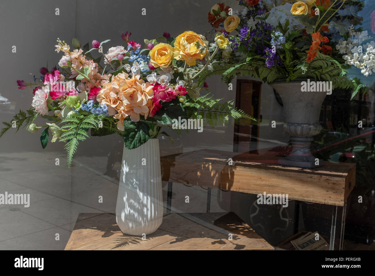 Künstliche Blumen im Fenster anzeigen Stockfoto