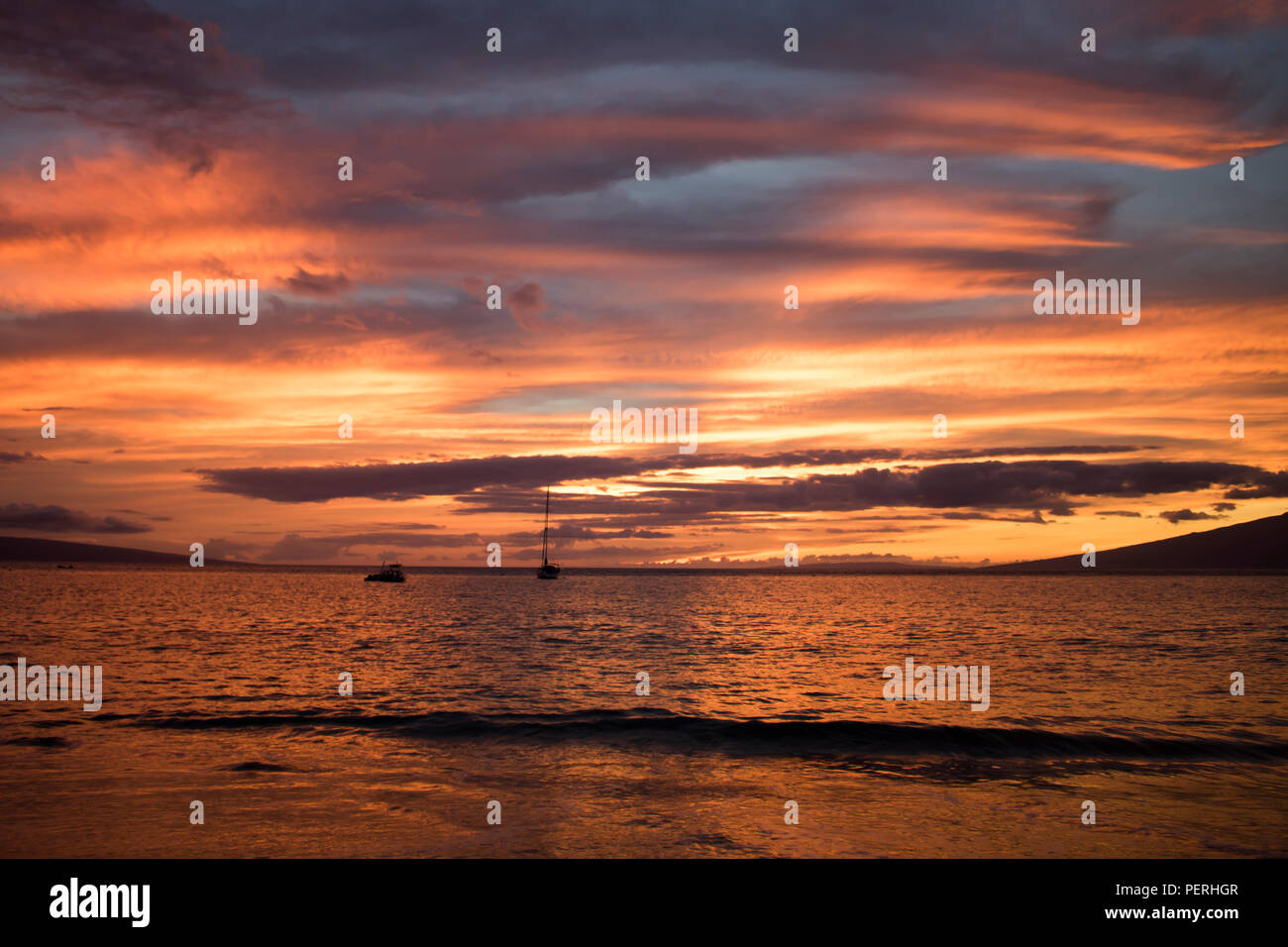 Helles orange Sonnenuntergang in Wolken und am Ocean wider Stockfoto