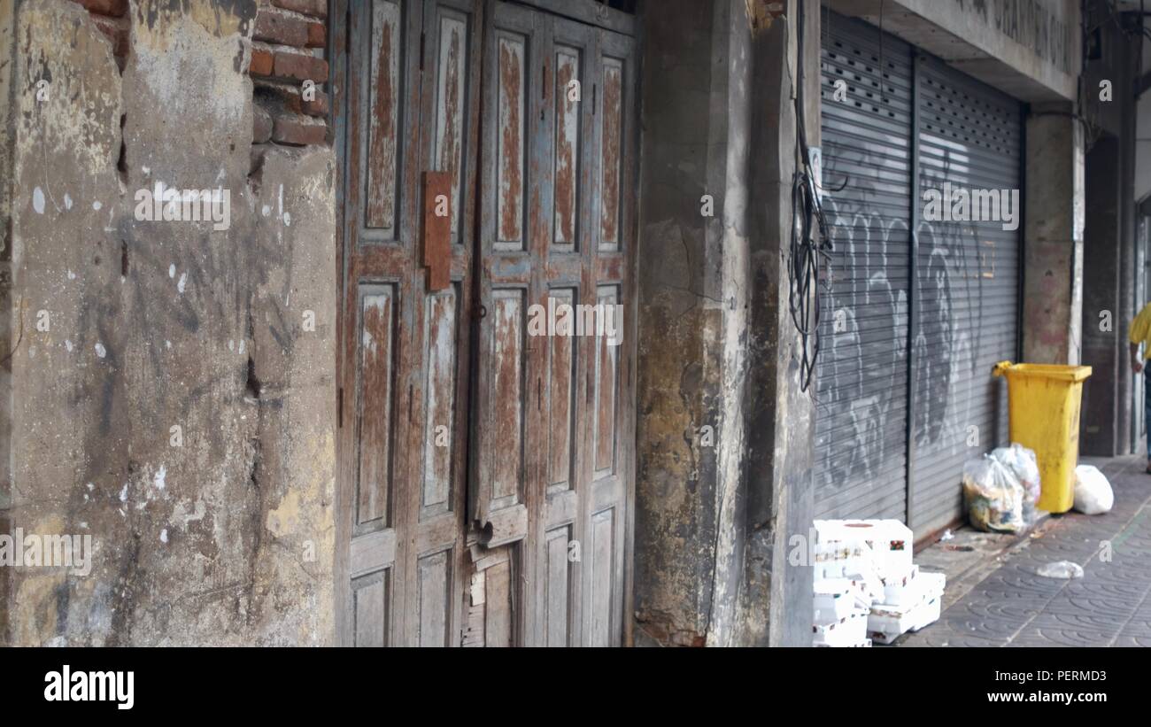 Hölzerne Tür zum jahrhundertealten, baufälligen historischen Denkmalgebäude an der Charoen Krung Road Chinatown Bangkok Thailand Urban Ghetto Reentwicklungsprogramm Stockfoto