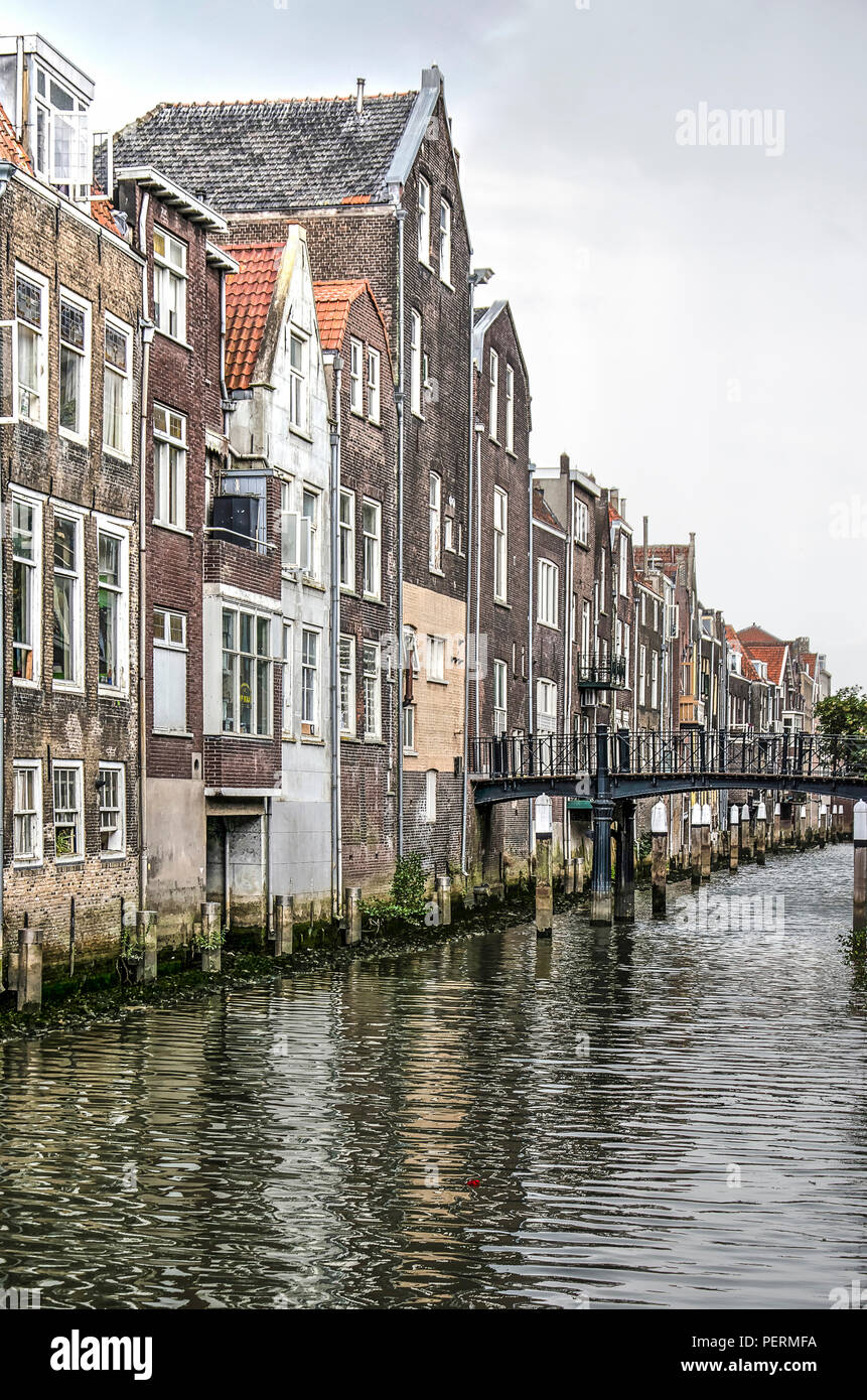 Dordrecht, Niederlande, 13. August 2018: Reihe von Häusern direkt auf Voorstraathaven Kanal mit einer Fußgängerbrücke aus Stahl zwischen zwei integrierte Stockfoto