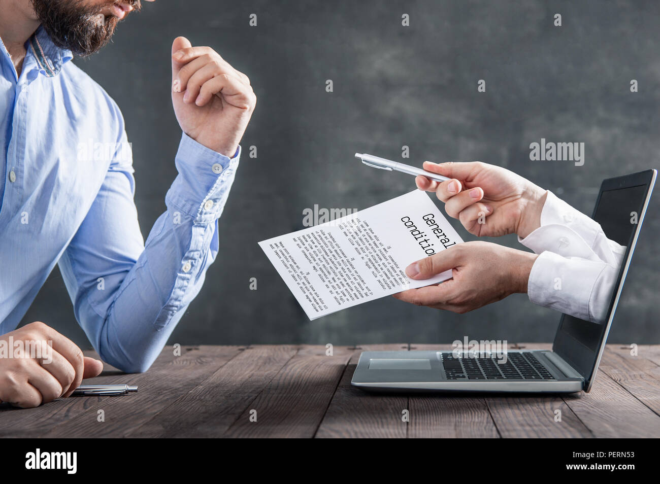 Geschäftsmann liest Allgemeine Bedingungen die Hände aus einem Laptop kommen. Metapher für die Unterzeichnung von Verträgen über das Internet Stockfoto