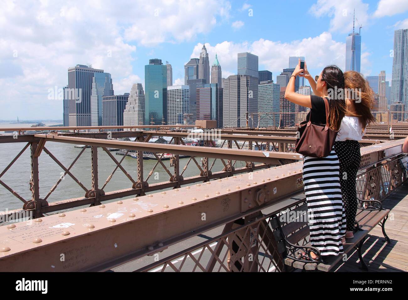NEW YORK, USA - Juli 5, 2013: Frauen machen Sie Fotos von der Brooklyn Bridge in New York. Fast 19 Millionen Menschen leben in New York City metropolitan area. Stockfoto