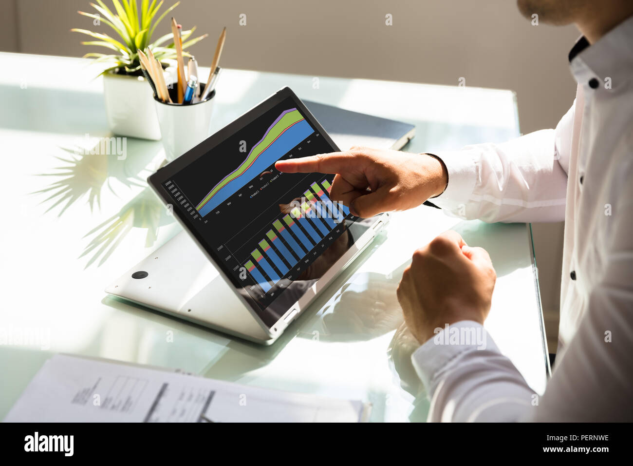 Nahaufnahme der Hand ein Geschäftsmann Analyse von Graphen auf Laptop am Arbeitsplatz Stockfoto