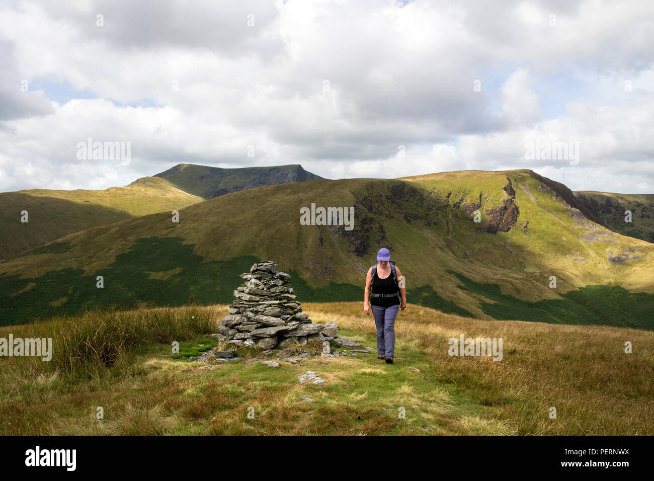Der Wanderer und die Ansicht von Souther fiel in Richtung Bannerdale Felsen und Blencathra, Lake District, Cumbria, Großbritannien Stockfoto