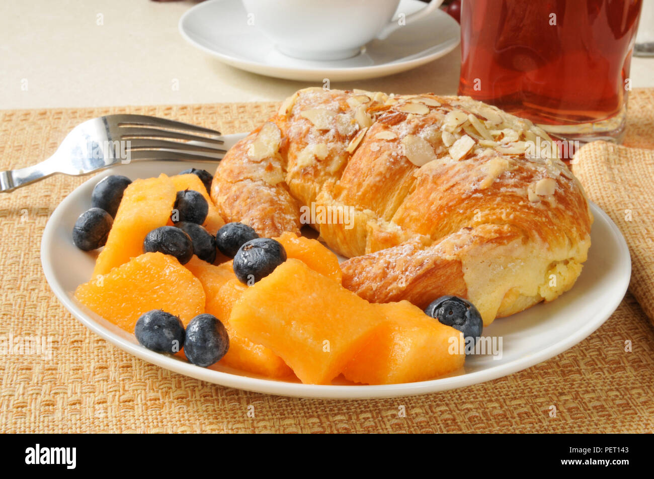 Ein Pudding gefüllte Mandel Croissant mit Melone, Blaubeeren und Saft Stockfoto