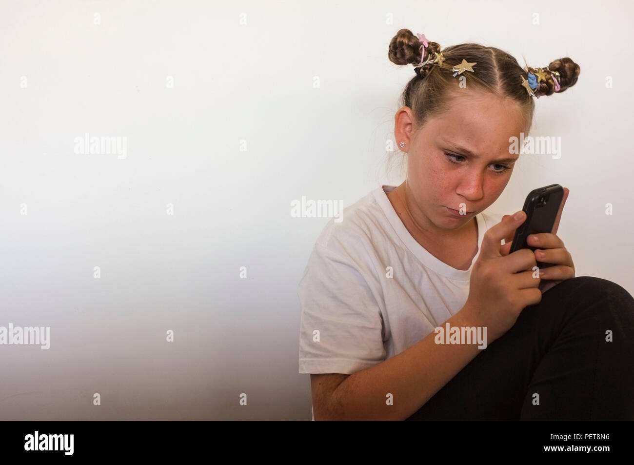 Pre-Teen Girl Interaktion mit einem Mobiltelefon. Stockfoto