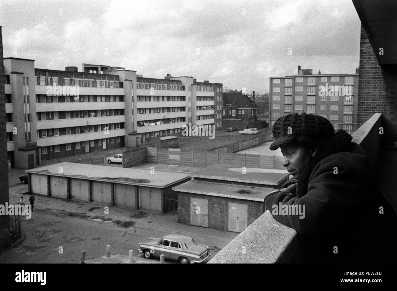 Armut in Großbritannien der 1970er Jahre, eine ältere schwarze britische Frau auf ihrem flachen Balkon auf dem landsitz Stonebridge Estate. Isoliert und alleine in einem Einzelzimmer mit kleiner Küche und Bad. Alles in sehr schlechtem Zustand, die Wohnung ist feucht und sehr kalt. Haggerston, East London, England 1978. 70er Jahre HOMER SYKES Stockfoto