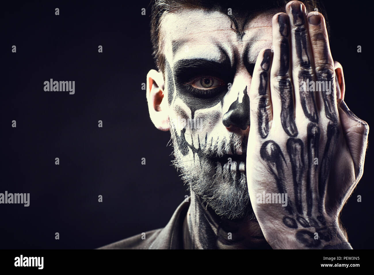 Antlitz des Menschen mit Halloween Skull Make-up auf dem schwarzen Hintergrund Stockfoto