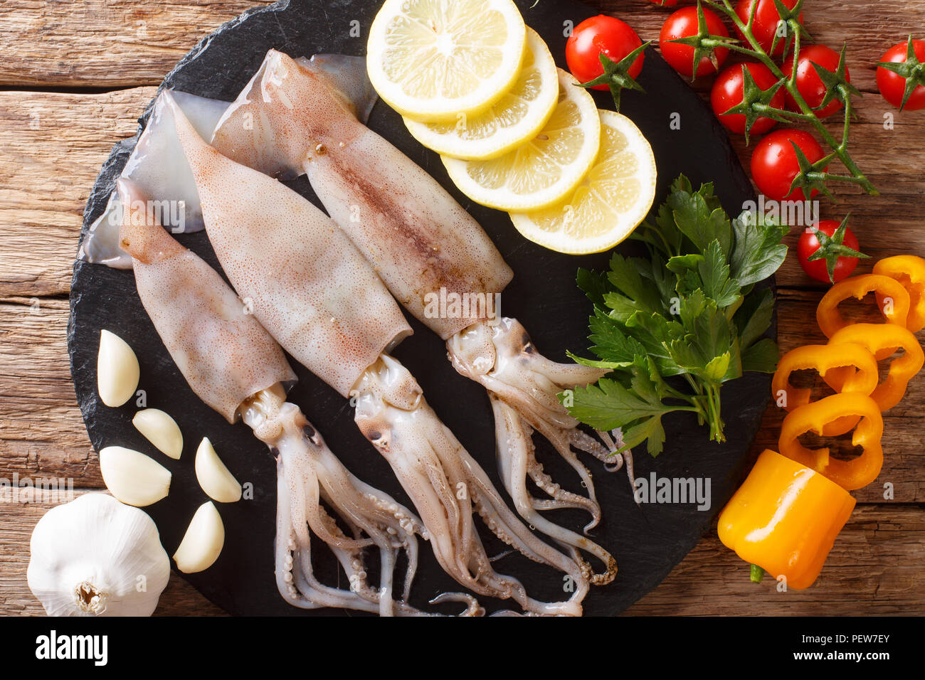 Meeresfrüchte frische Tintenfische mit Tentakeln close-up und Gemüse für die Küche auf den Tisch. horizontal oben Ansicht von oben Stockfoto