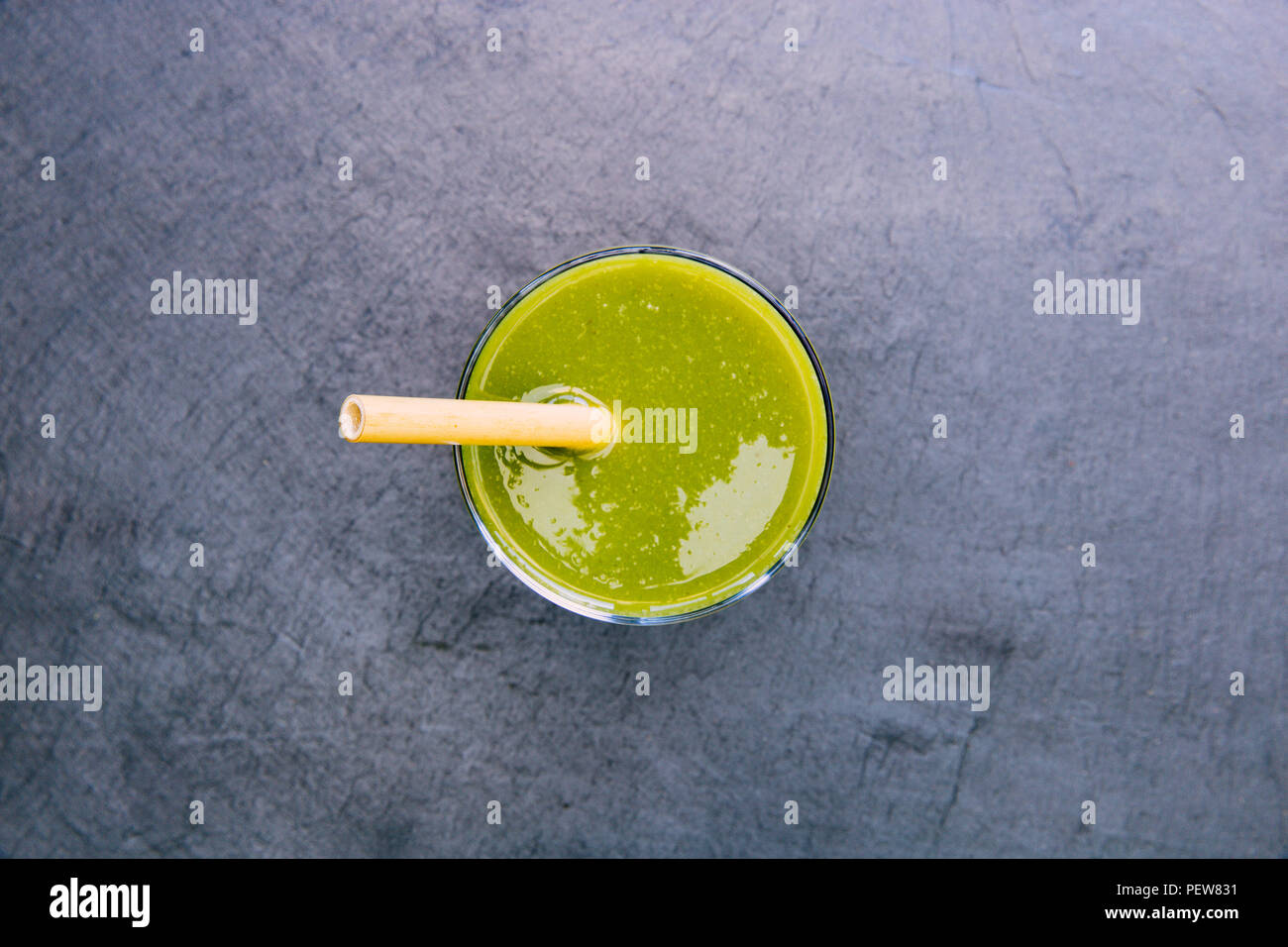 Grüne Smoothie trinken mit Stroh auf dunklem Hintergrund Stockfoto