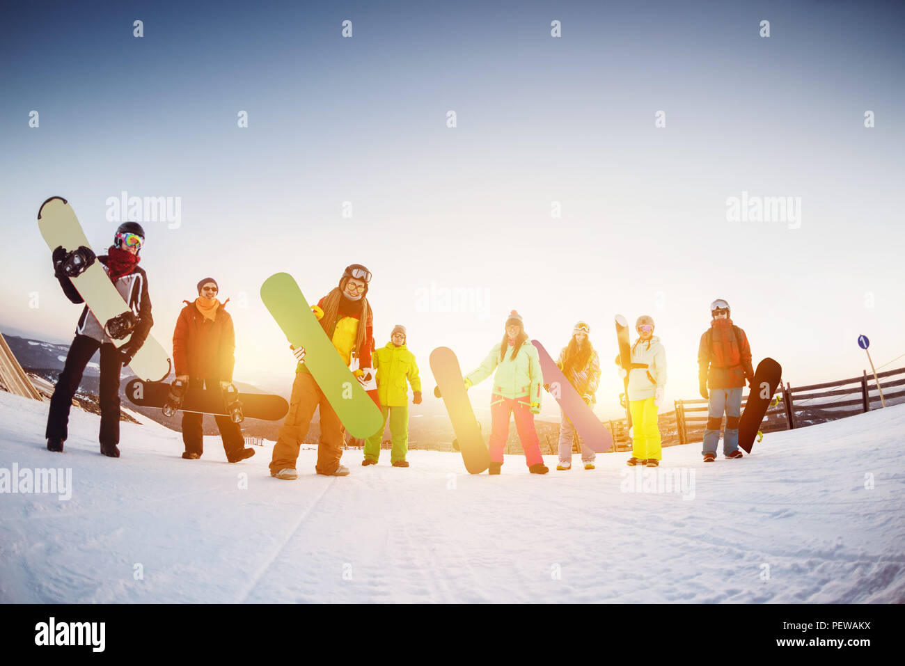 Gerne Freunde Snowboarder sind Spaß an der Skistation gegen Sonnenuntergang Licht Stockfoto