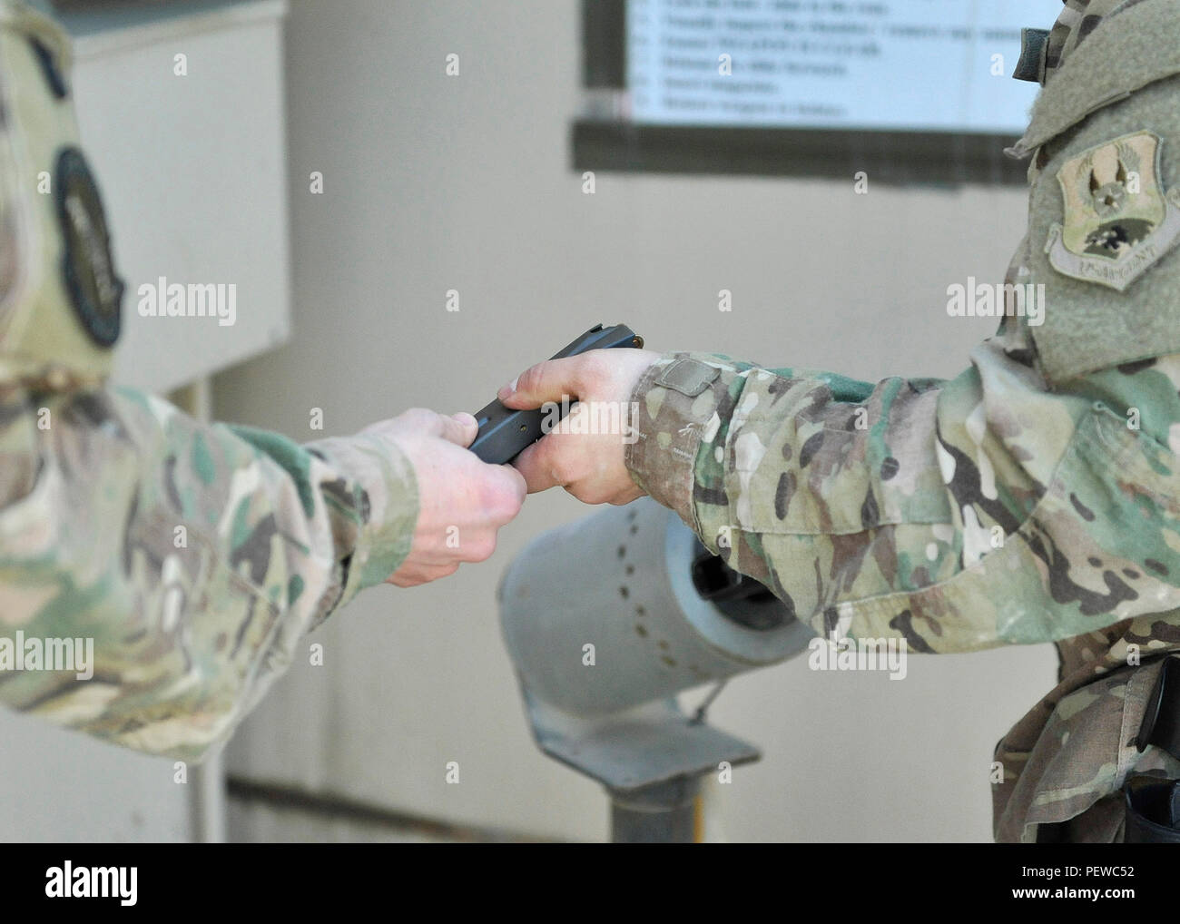 Staff Sgt. Garrett Jacobs (links), eine munitions Systeme von der 455th Expeditionary Maintenance Squadron Handwerker, Hände, ein Magazin zu einem Flieger seine Pistole auf Bagram Air Field, Afghanistan, Feb 4, 2016 zu laden. Jacobs ist der einzige NCO für die Ausstellung, die Kontrolle und die Verantwortlichkeit von Zehntausenden von Kleinwaffen Umläufe bei Bagram verantwortlich. (U.S. Air Force Foto vom Kapitän Bryan Bouchard) Stockfoto