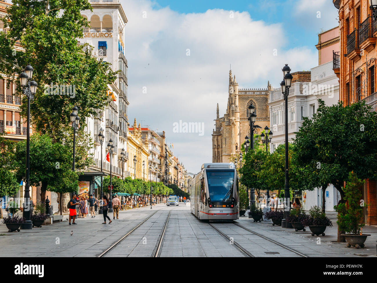 Sevilla, Spanien - 15. Juli 2018: Elektrische Straßenbahn auf der Constitution Avenue mit iconic Sevilla Kathedrale im Hintergrund Stockfoto