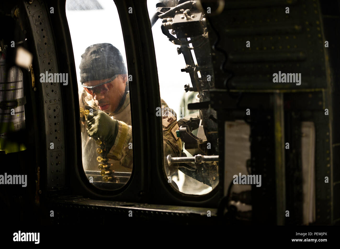 Us Air Force Staff Sgt. Keon Miller, spezielle Missionen aviator, 823 Maintenance Squadron, lasten Munition zu einem HH-60G Pave Hawk zur Unterstützung der integrierten Übung (ITX) 2-16 auf der strategischen Expeditionary Landeplatz an Bord Marine Corps Air Ground Combat Center Twentynine Palms, Calif., Feb 1, 2016. MCAGCC führt entsprechende live-fire kombinierte Waffen, städtische Betriebe und gemeinsamer/Koalition level Integration Schulung, die operativen Kräfte' Bereitschaft fördern. (U.S. Air Force Foto von älteren Flieger Matthew L. Garcia/Freigegeben) Stockfoto