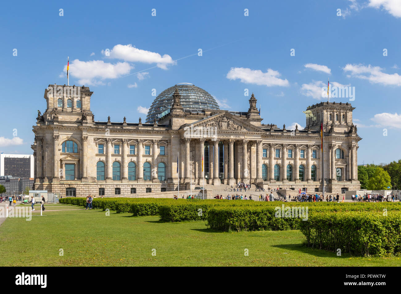 BERLIN, DEUTSCHLAND - Apr 28, 2018: die Menschen entspannen auf der Wiese vor dem Reichstag, Sitz des deutschen Parlaments (Deutscher Bundestag). Stockfoto