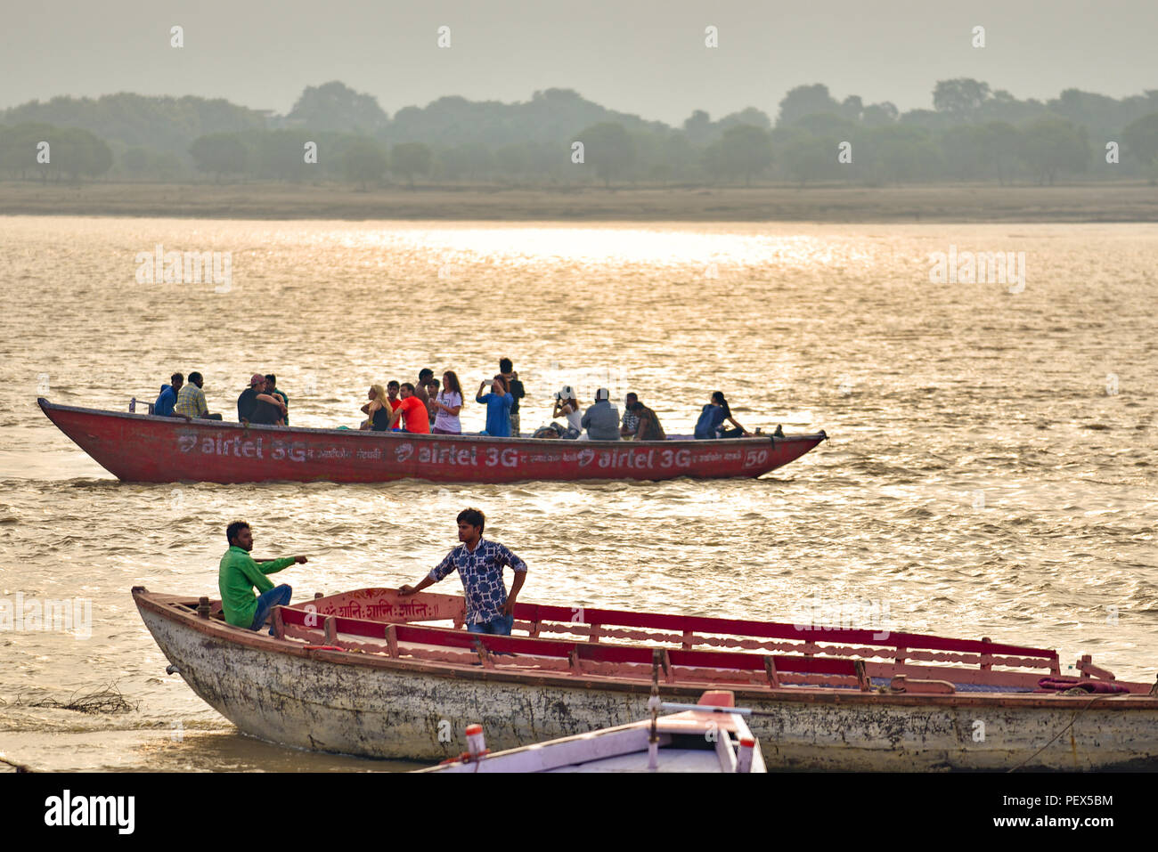 Indische Menschen auf Booten am Ganges am Morgen mit goldenem Licht Stockfoto