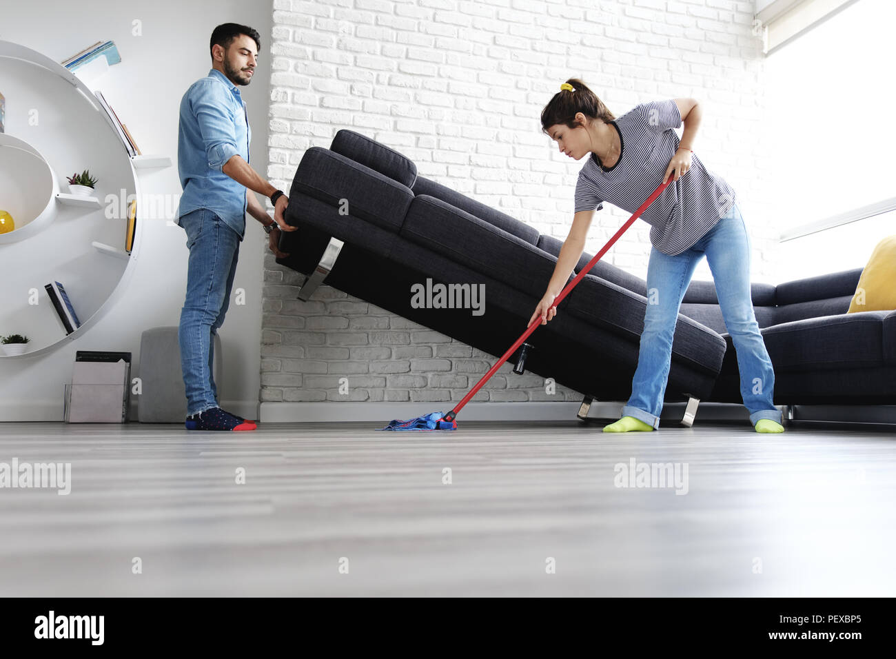 Mann und Frau tun Chores Reinigung Boden Stockfoto