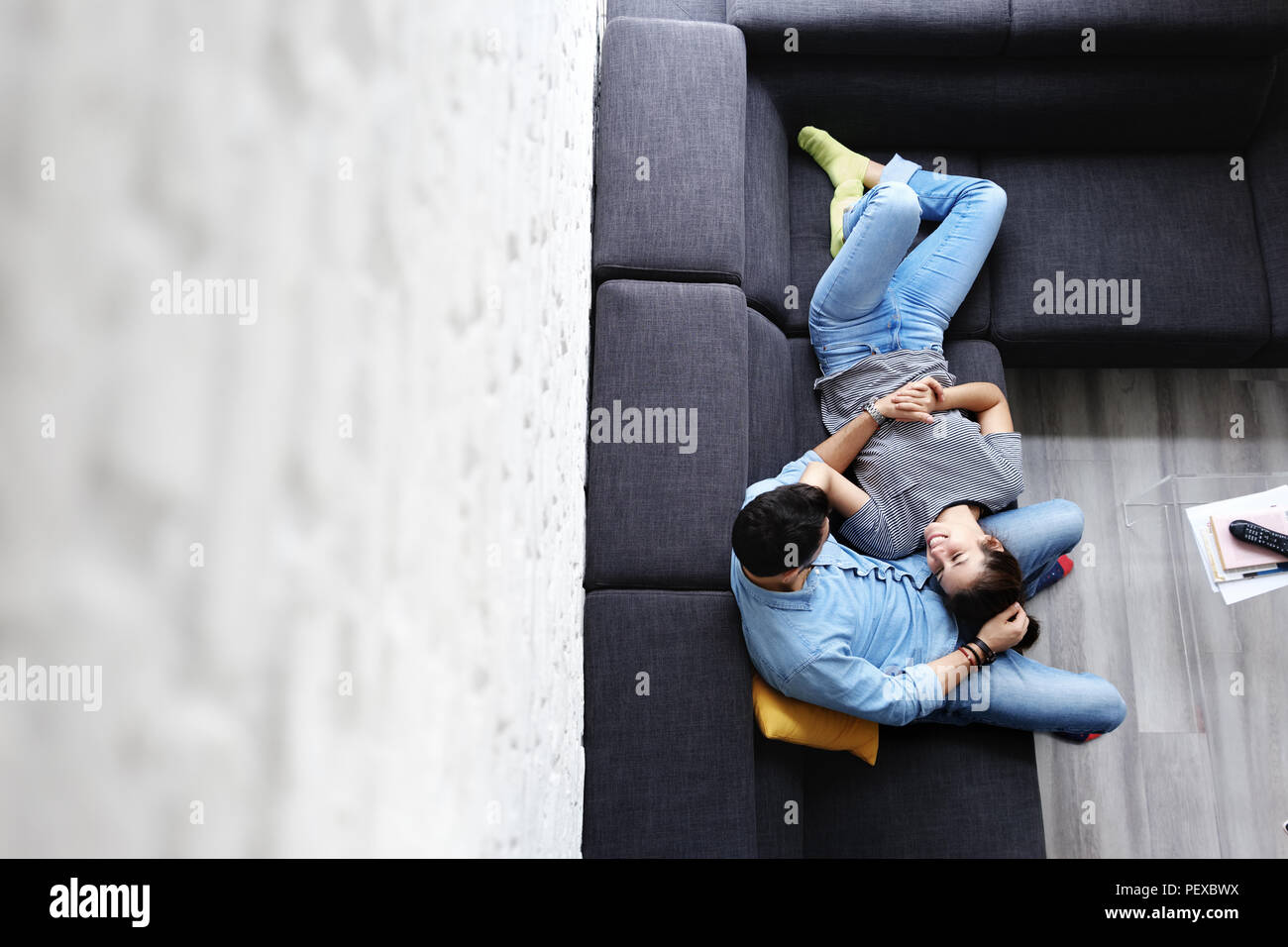 Junges Paar umarmen und lachend auf dem Sofa Stockfoto