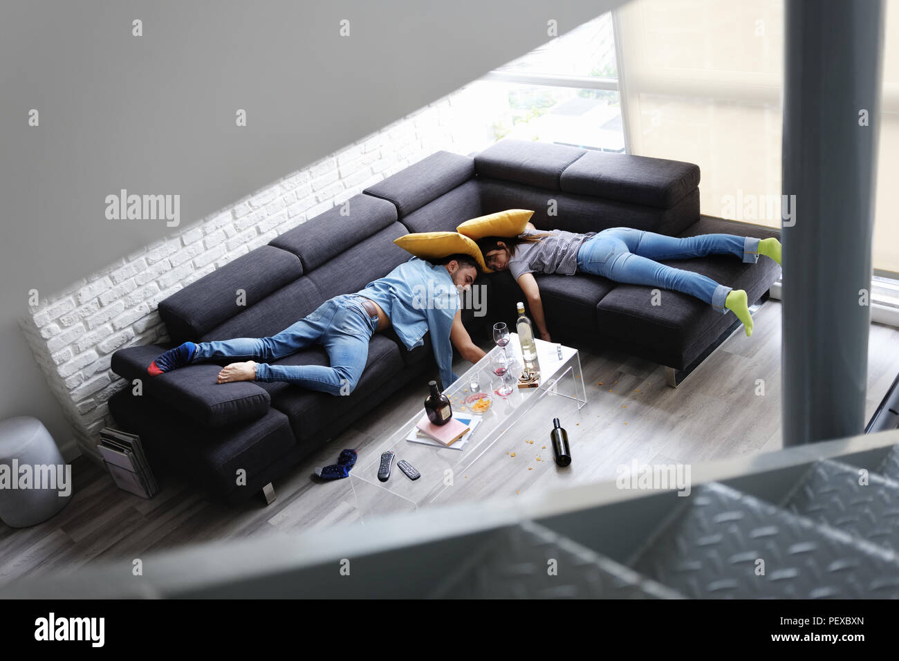 Betrunkene Freunde schlafen auf dem Sofa in unordentlichen Zimmer nach Partei Stockfoto