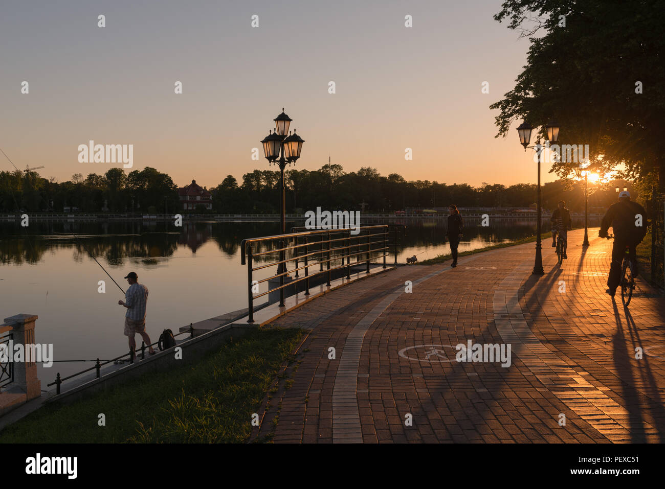 Promenade entlang der Oberteich oder Oberen See, Abendlicht, Mann angeln, Kaliningrad, Oblast Kaliningrad, Russland Stockfoto