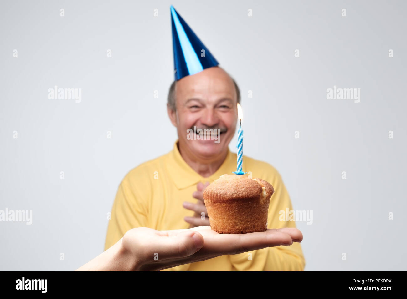 Gerne älterer Mann in birtyday hat ist happpy kleine Kuchen mit einer Kerze zu erhalten. Ich bin so froh, dass Du über meine Partei Konzept erinnern Stockfoto