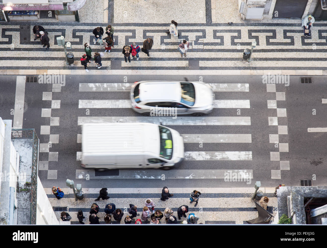 Lissabon, Portugal - 11. März 2016: ein Transporter und ein Auto fahren über ein Zebra striped Fußgängerüberweg in der Baixa von Lissabon, gesehen Stockfoto