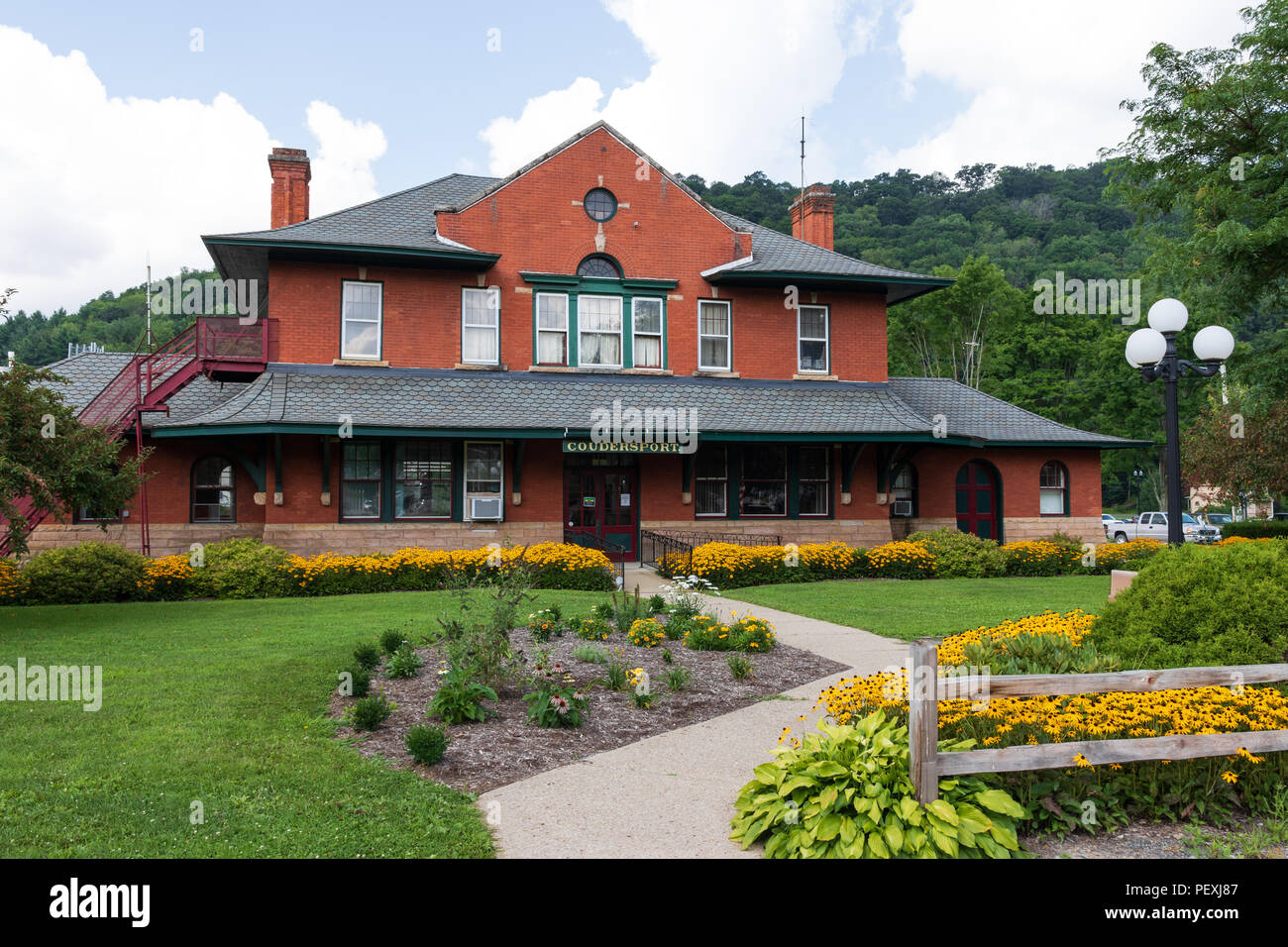 COUDERSPORT, PA, USA-10 18. AUGUST: Der Stadt alter Bahnhof, mit einem farbenfrohen, sorgfältig gepflegten Rasen. Stockfoto