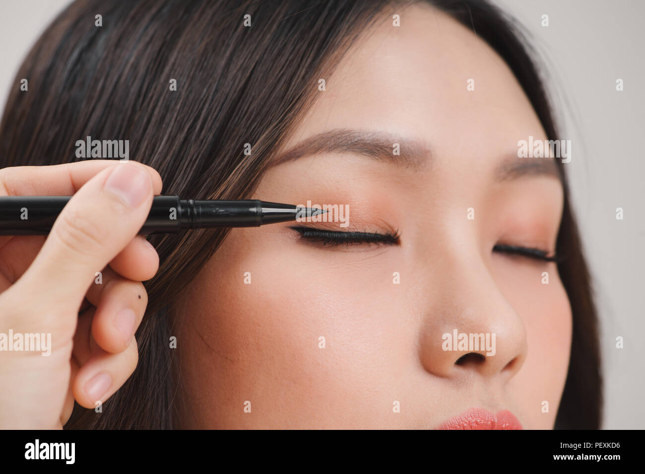 Make-up Schönheit mit Pinsel Eye Liner auf hübsche Frau Gesicht Stockfoto
