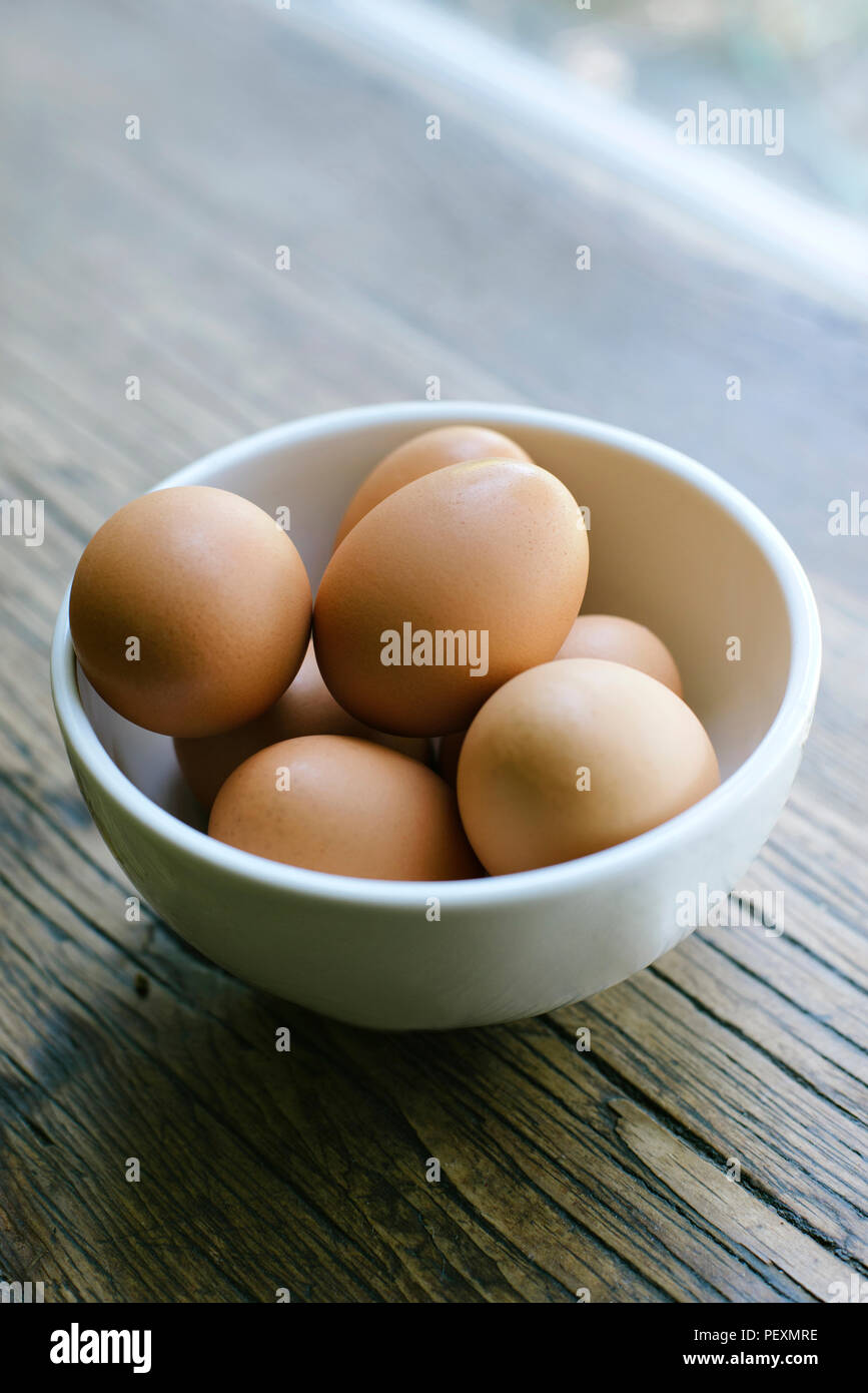 Frische Eier fein in eine Schüssel auf dem Bauernhof Tisch Stockfoto