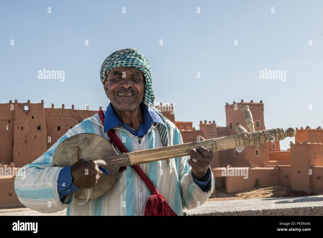 Berber Mann spielt Instrument für Touristen in Marokko Stockfoto