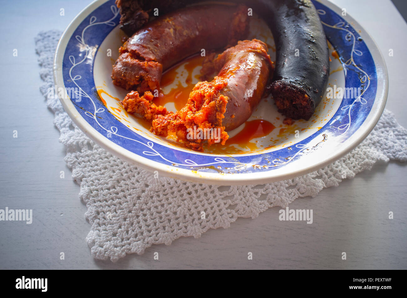 Rot und Schwarz Chorizo Wurst morcilla nur gekocht auf einer Platte über stricken Tuch. Nahaufnahme Stockfoto