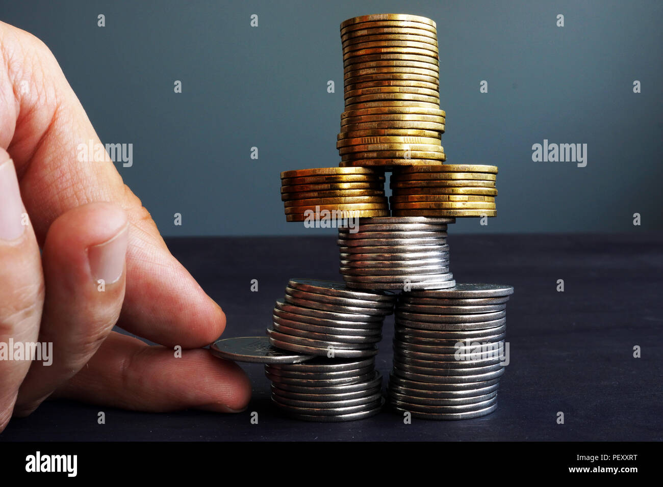 Finanzielle Stabilität Konzept. Mann mit Münzen im Münzen stapeln. Stockfoto