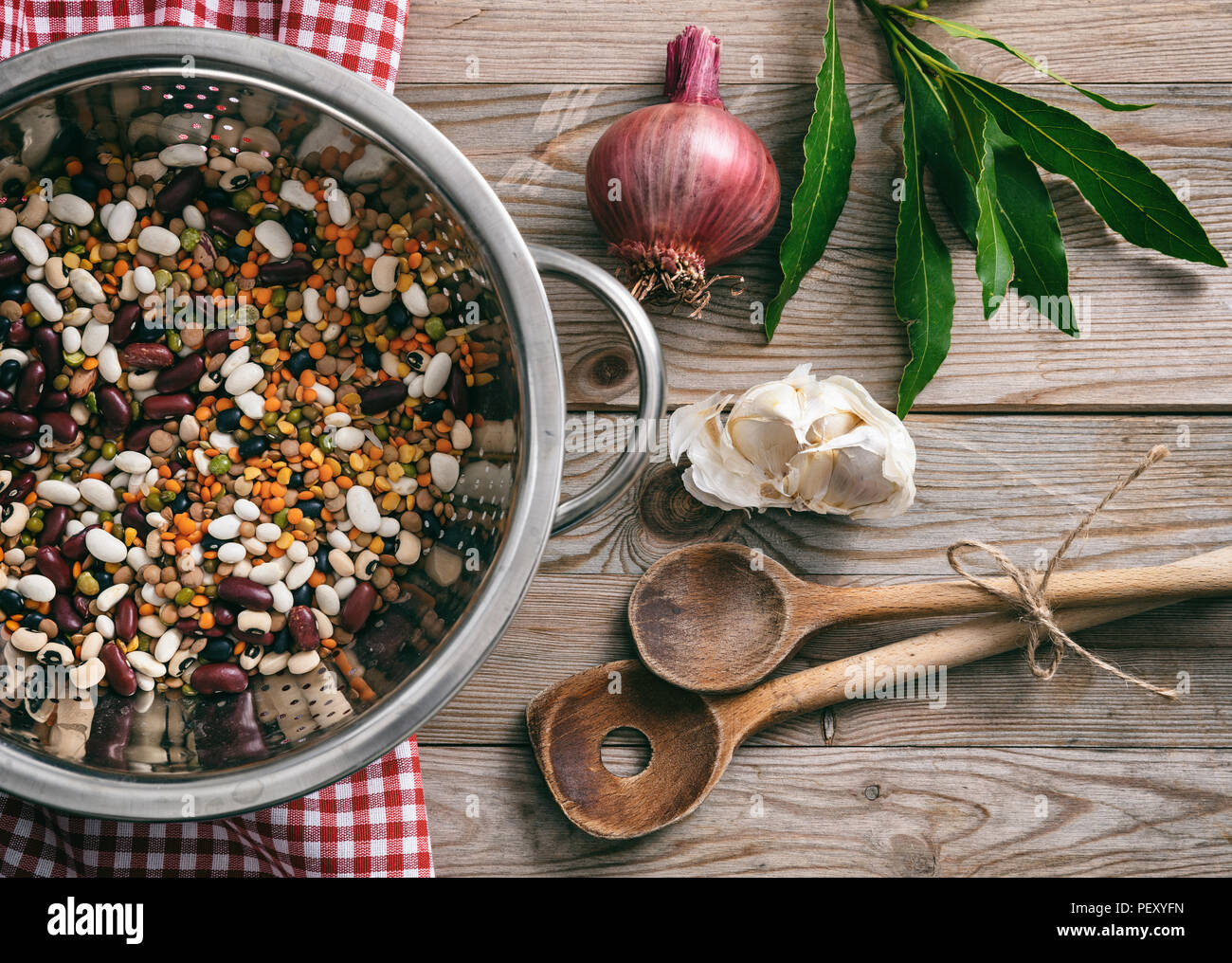 Gesundes Kochen. Gemischtes Gemüse, Kräutern und roten Tischdecke auf Holztisch, Ansicht von oben Stockfoto