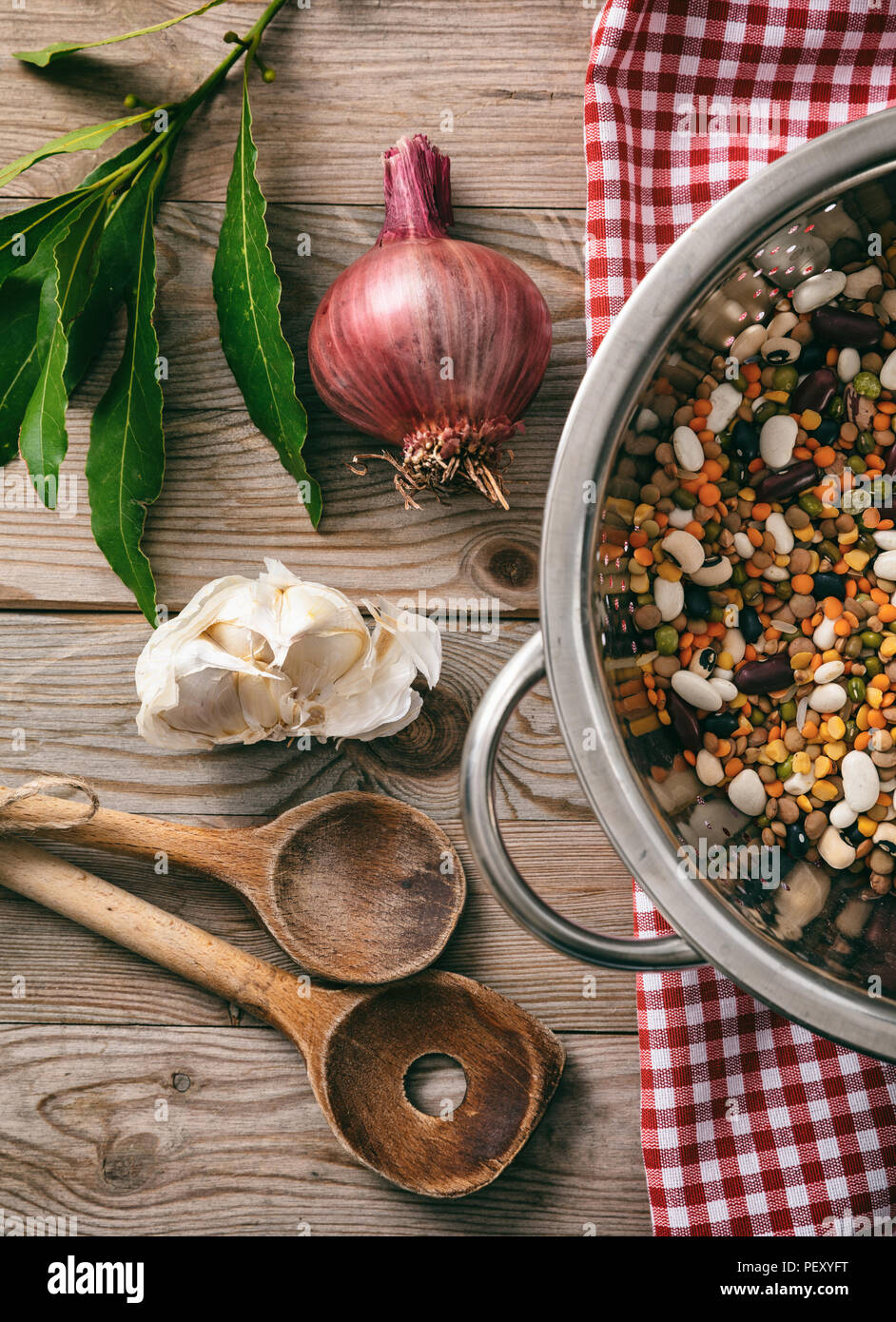 Gesundes Kochen. Gemischtes Gemüse, Kräutern und roten Tischdecke auf Holztisch, Ansicht von oben Stockfoto