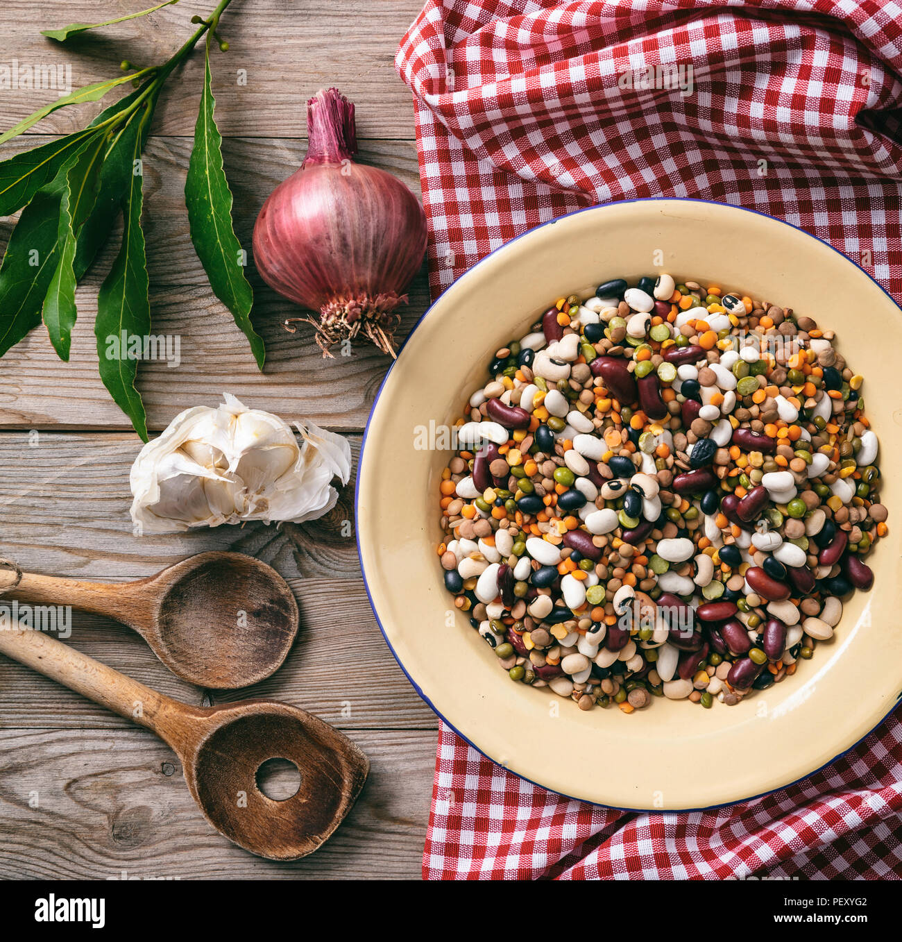 Gesundes Kochen. Gemischtes Gemüse, Kräutern und roten Tischdecke auf Holztisch, Ansicht von oben Stockfoto