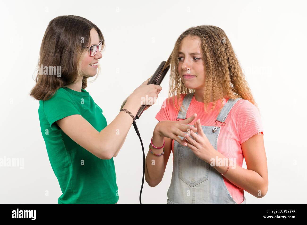 Portrait von zwei Jugendlichen Freundinnen Haarschnitt zuhause tun. Weißer Hintergrund. Stockfoto