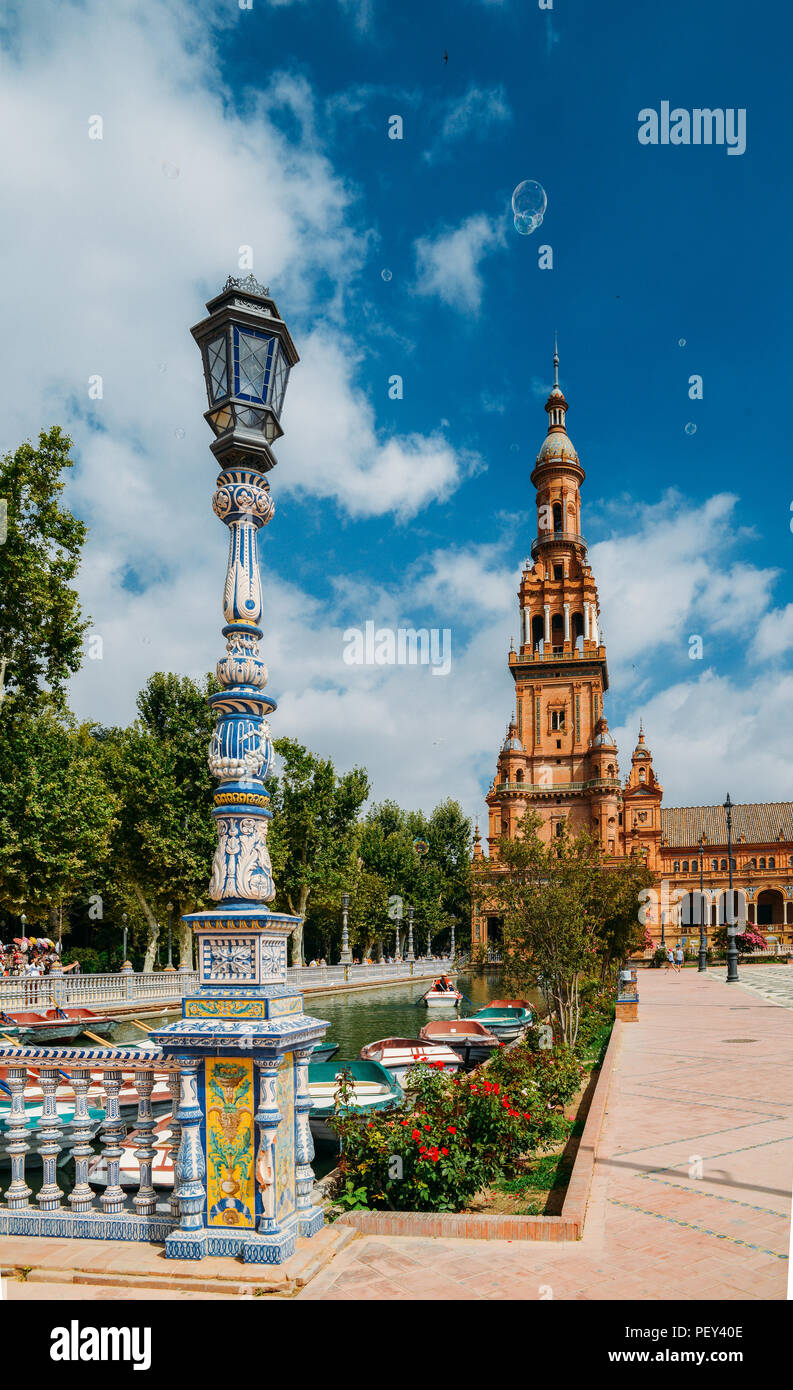 Sevilla Spanien - 15. Juli 2018: Gegenüberstellung von blau und weiß Keramik Azulejo Kacheln gegen eine der barocken Sandstein Turm an der Plaza de Espana in Stockfoto