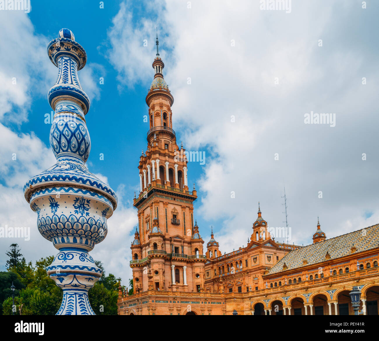 Sevilla Spanien - 15. Juli 2018: Gegenüberstellung von blau und weiß Keramik Azulejo Kacheln gegen eine der barocken Sandstein Turm an der Plaza de Espana in Stockfoto